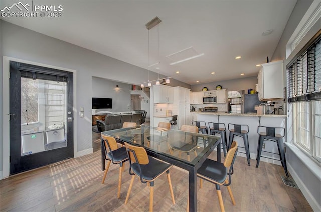 dining area featuring recessed lighting, a healthy amount of sunlight, visible vents, and light wood finished floors