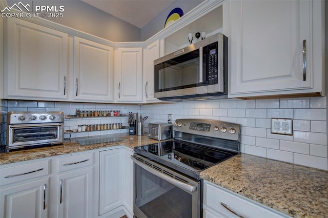 kitchen featuring tasteful backsplash, a toaster, light stone countertops, stainless steel appliances, and white cabinetry