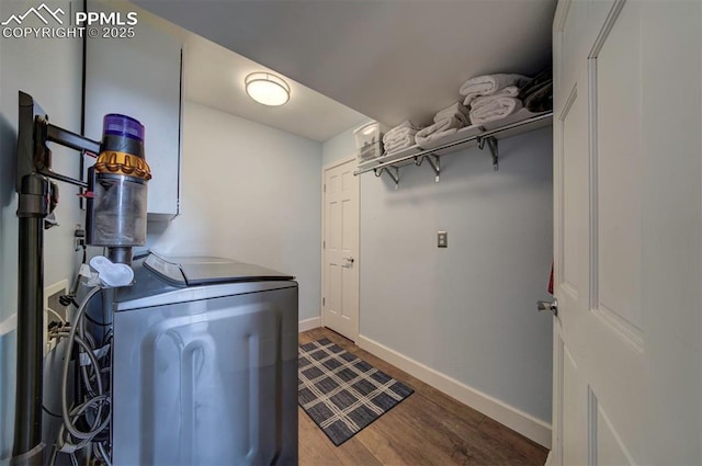 laundry area with laundry area, dark wood-type flooring, washer and clothes dryer, and baseboards