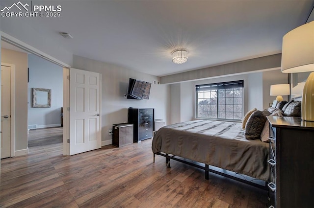 bedroom featuring baseboards and wood finished floors