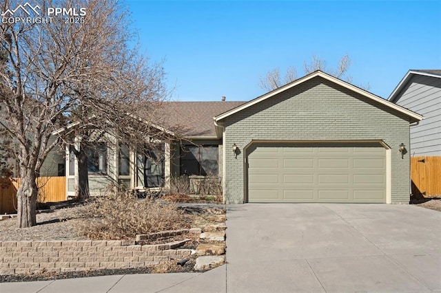 single story home featuring a garage, driveway, brick siding, and fence