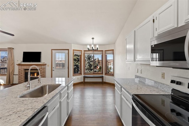 kitchen with a wealth of natural light, dark wood finished floors, stainless steel appliances, and a sink