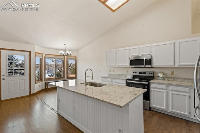 kitchen featuring dark wood-style floors, appliances with stainless steel finishes, white cabinets, a sink, and an island with sink