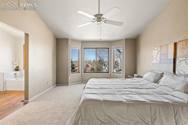 bedroom with a textured ceiling, carpet flooring, a ceiling fan, baseboards, and ensuite bath