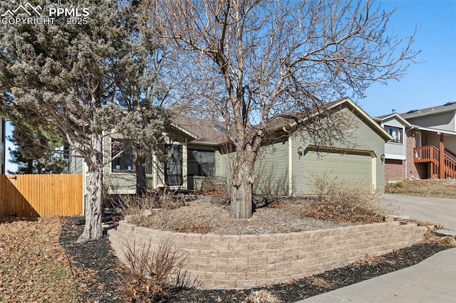 view of front of home with driveway, an attached garage, fence, and brick siding