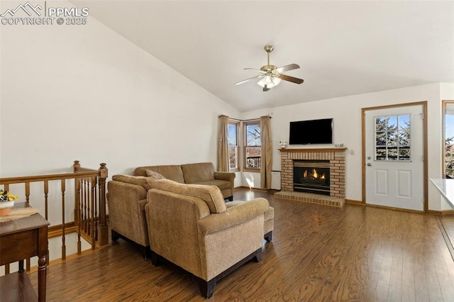 living area featuring baseboards, a ceiling fan, wood finished floors, vaulted ceiling, and a fireplace