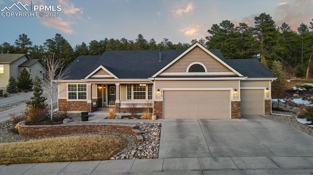 craftsman house with a garage, covered porch, and concrete driveway