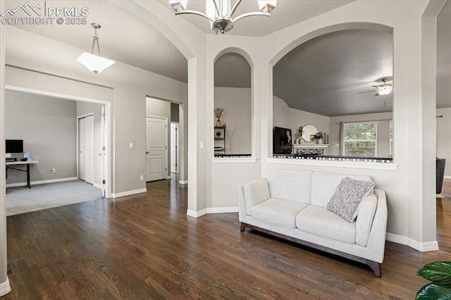 living area featuring baseboards, wood finished floors, and ceiling fan with notable chandelier