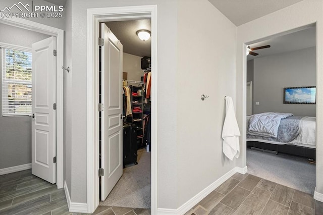 hall featuring baseboards and wood tiled floor