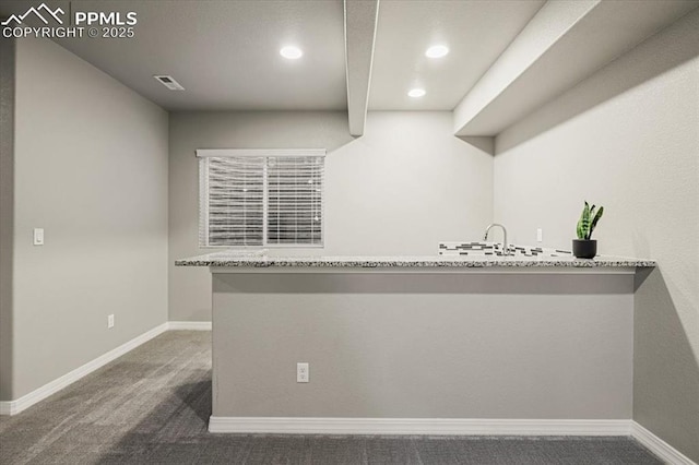 kitchen featuring visible vents, baseboards, carpet, and light stone countertops