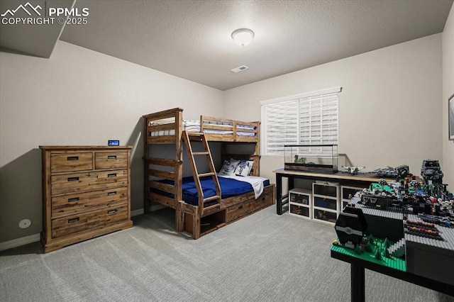 bedroom with baseboards, carpet flooring, a textured ceiling, and visible vents