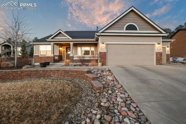 craftsman-style house with stone siding, a porch, concrete driveway, and an attached garage