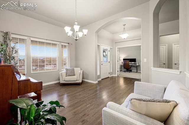 sitting room with a chandelier, baseboards, and wood finished floors