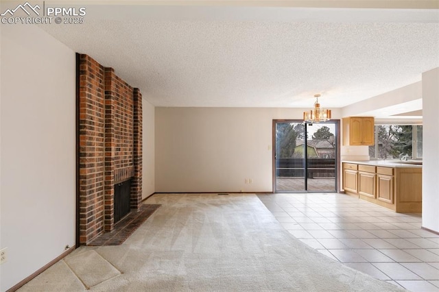 unfurnished living room with a textured ceiling, a fireplace, light tile patterned flooring, and light colored carpet