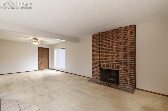 unfurnished living room with carpet, a fireplace, a textured ceiling, and baseboards