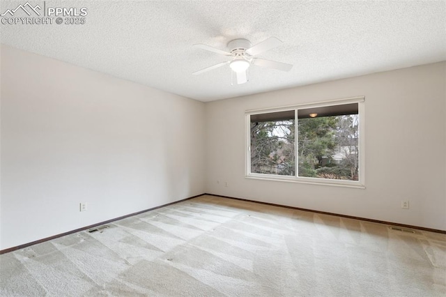 empty room featuring a textured ceiling, visible vents, and carpet flooring