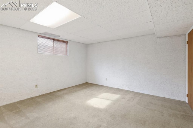 basement featuring a drop ceiling and carpet flooring