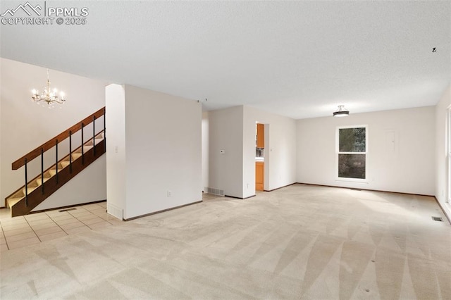 unfurnished room featuring a notable chandelier, visible vents, light colored carpet, stairway, and a textured ceiling