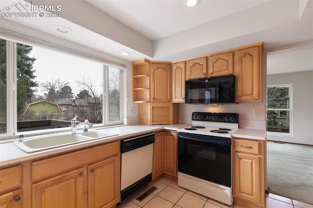 kitchen featuring plenty of natural light, white appliances, light countertops, and a sink