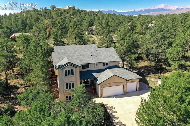 aerial view featuring a forest view and a mountain view