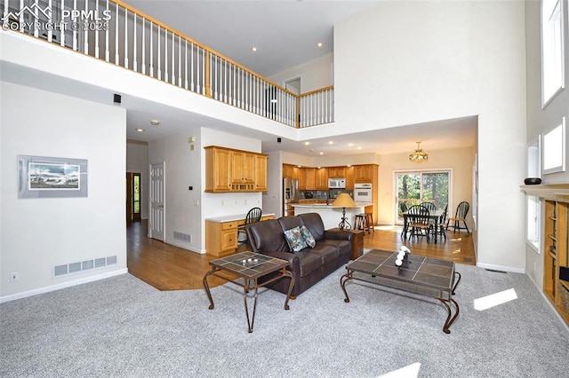 carpeted living area with recessed lighting, baseboards, and visible vents