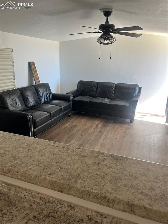 living area with ceiling fan and wood finished floors