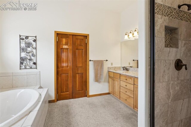 full bathroom with vanity, a tile shower, a bath, and baseboards