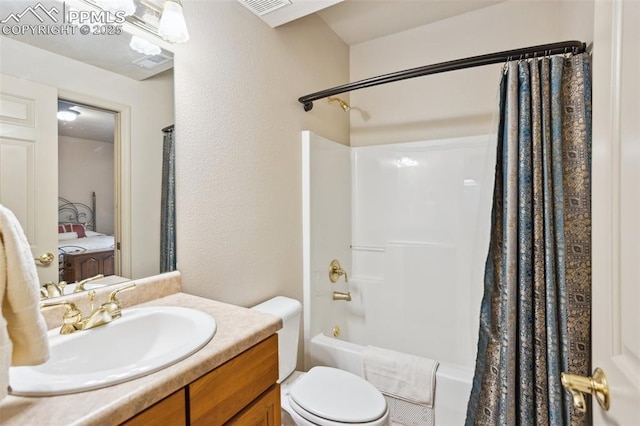 bathroom featuring a textured wall, shower / tub combo, vanity, and toilet