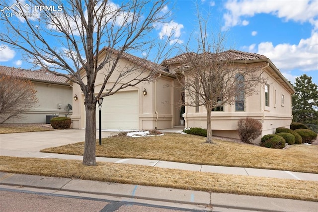 view of front facade featuring driveway, a tile roof, an attached garage, cooling unit, and stucco siding