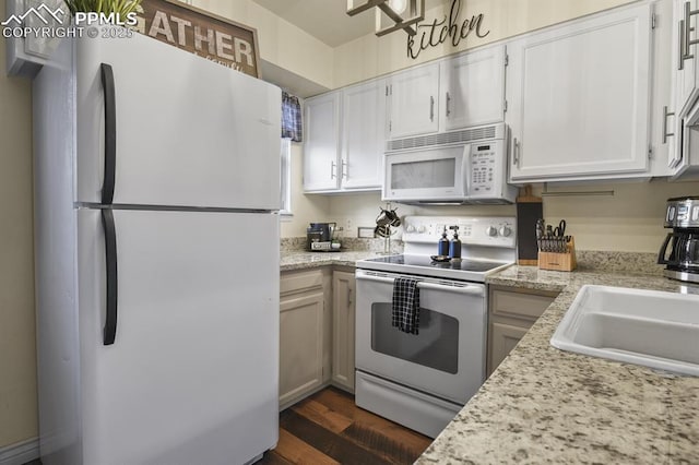 kitchen with a sink, white appliances, white cabinetry, and light countertops