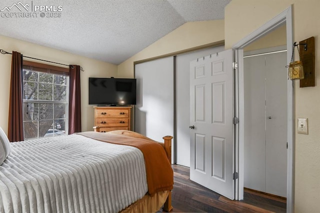 bedroom with a closet, a textured ceiling, lofted ceiling, and wood finished floors