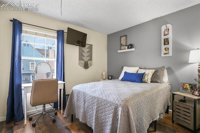 bedroom featuring baseboards, dark wood-style flooring, and a textured ceiling