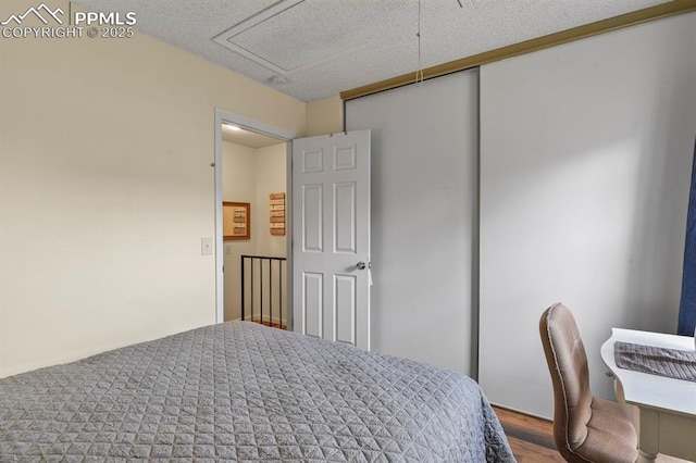 bedroom with wood finished floors and a textured ceiling