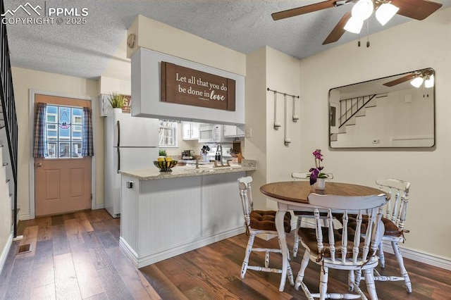 dining space featuring stairs, dark wood-type flooring, baseboards, and a textured ceiling