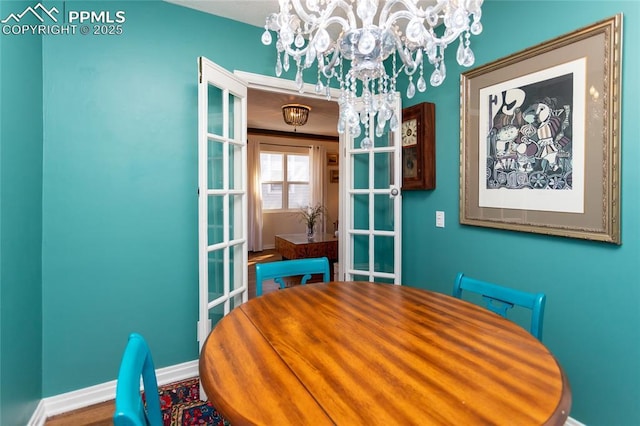 dining area with baseboards and a chandelier