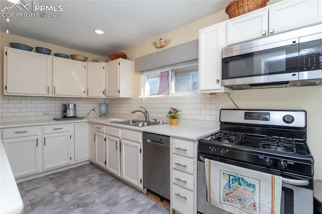 kitchen featuring a sink, appliances with stainless steel finishes, and white cabinetry