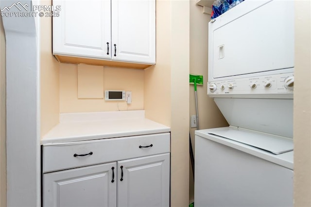 clothes washing area featuring stacked washer / dryer