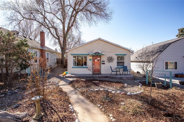 bungalow-style home featuring stucco siding and a patio area