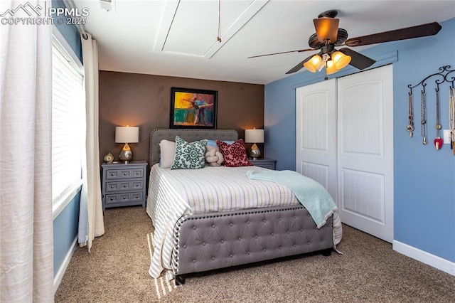 carpeted bedroom with baseboards, multiple windows, attic access, and a closet