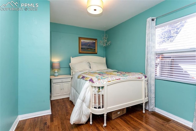 bedroom with visible vents, wood finished floors, and baseboards