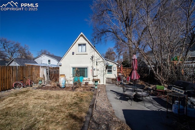 back of house featuring a patio area, stucco siding, a yard, and fence