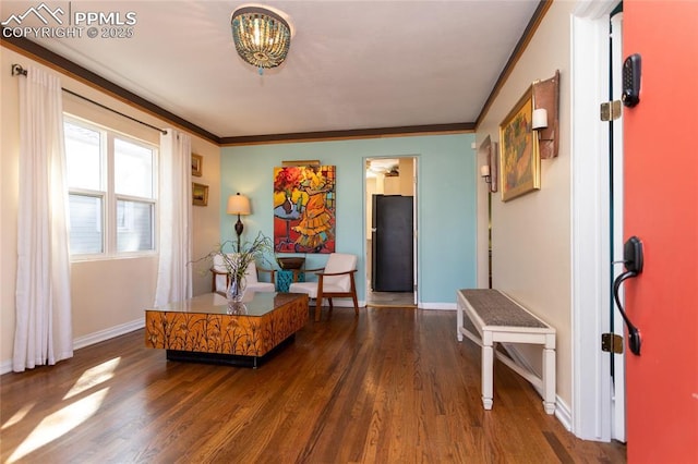 foyer with crown molding, wood finished floors, and baseboards