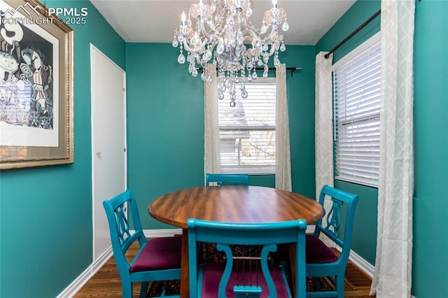 dining area featuring an inviting chandelier, wood finished floors, and baseboards