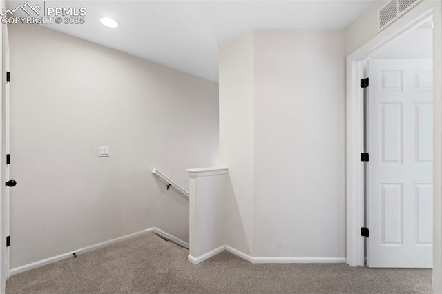 corridor with baseboards, visible vents, carpet flooring, and an upstairs landing