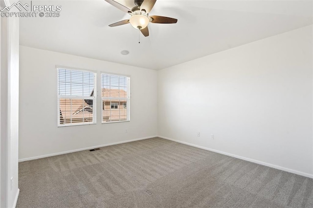 carpeted spare room featuring visible vents, baseboards, and ceiling fan