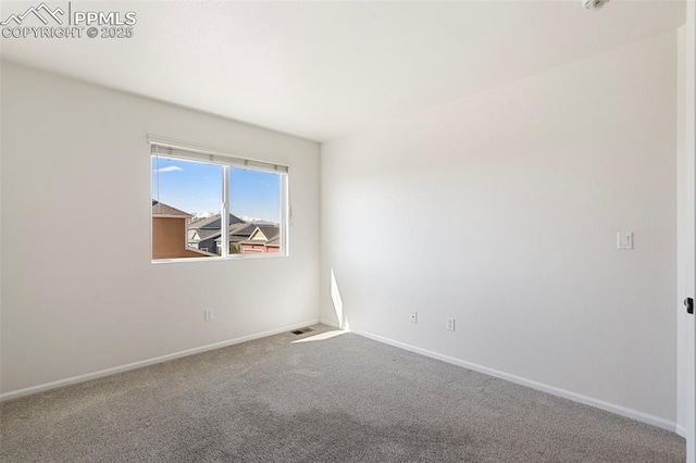 carpeted spare room with visible vents and baseboards