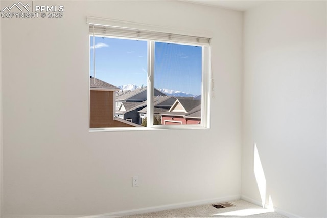 unfurnished room featuring carpet, visible vents, and baseboards