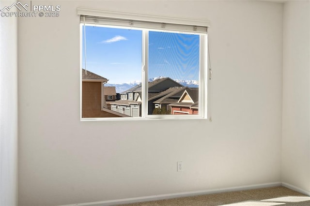 carpeted empty room with baseboards