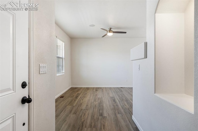 spare room featuring ceiling fan, wood finished floors, and baseboards