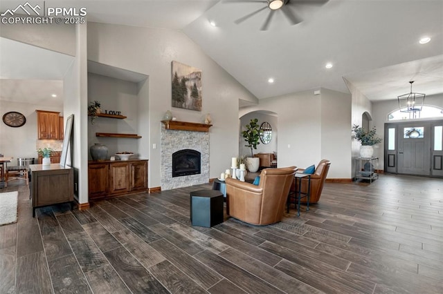 17820 Pioneer Xing, Colorado Springs, CO 80908 - living room featuring a ceiling fan, dark wood finished floors, a stone fireplace, arched walkways, and high vaulted ceiling